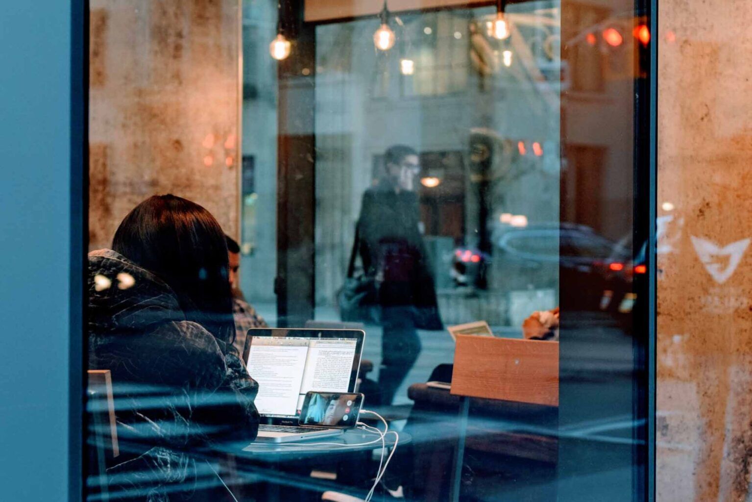 kvinne sitter på café og jobber