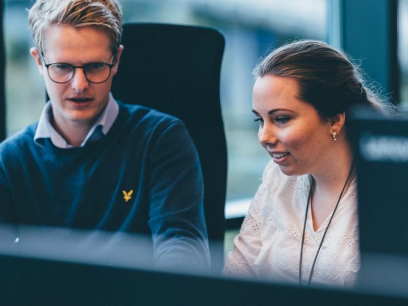 To konsulenter foran en skjerm