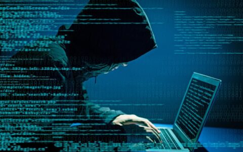 Hacker i hettegenser foran laptop